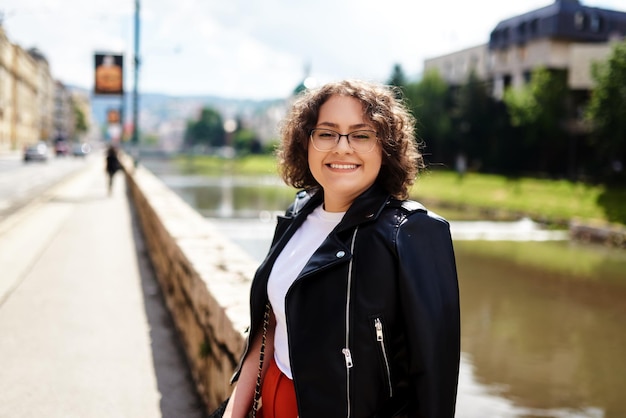 Ritratto laterale di una donna afroamericana sorridente che cammina in città