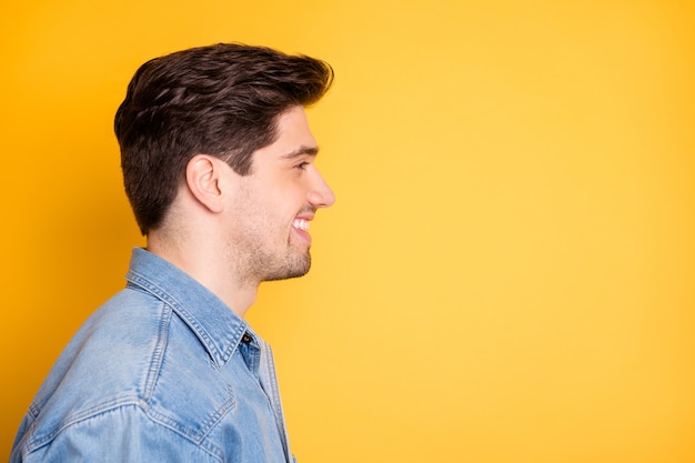 Profilo laterale vicino foto di allegro uomo positivo trentadue denti sognando comtemplando lo spazio vuoto di fronte a lui isolato muro di colori vivaci