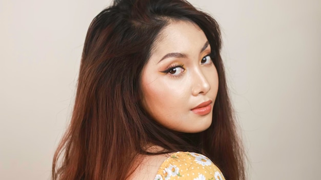 Side profile of a young Asian woman wearing makeup isolated with white background Beauty concept