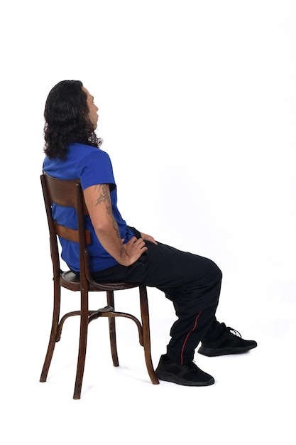 Side and rear view of a man with sportswear sitting on chair  on white background