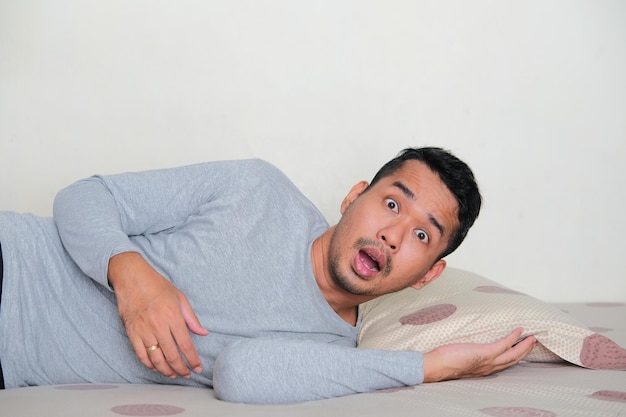 Side view of Adult Asian man wake up with shocked face expression