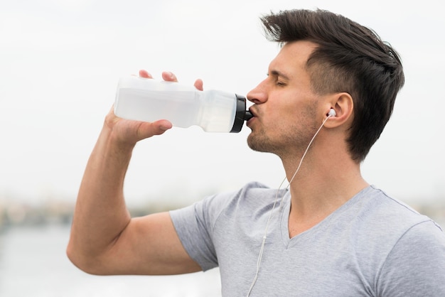 Photo side view adult man drinking water