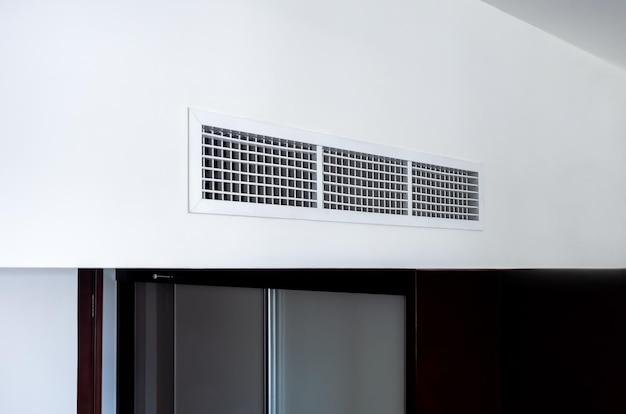 Side view of air conditioning wall mounted ventilation system on ceiling in the black and white hotel room Hotel room air ventilation grill on the wall