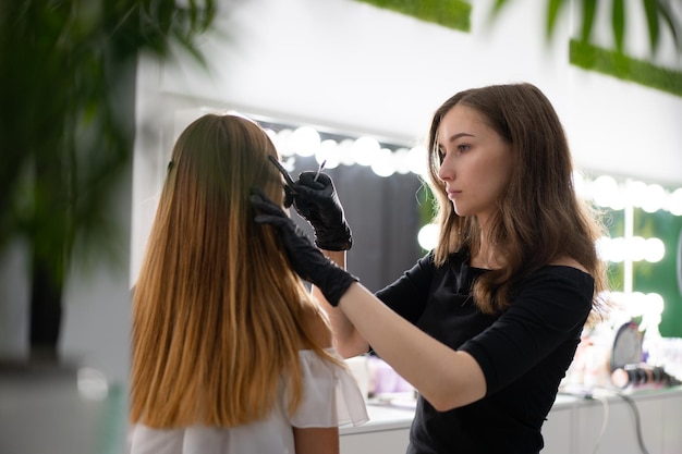 Side view of artist applying make-up on woman