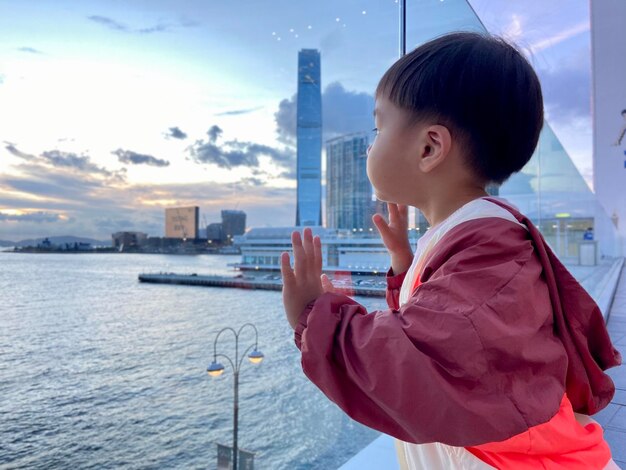 Foto vista laterale di un ragazzo asiatico che guarda il mare