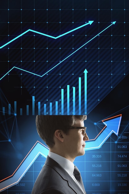 Side view of attractive young businessman with half business chart head thinking about profit and money income on blue background with growing arrow Business strategy and growth concept