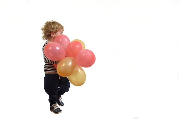 Side view of a baby playing with air balloon on white background