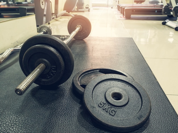 Side view of barbell on the floor in fitness gym