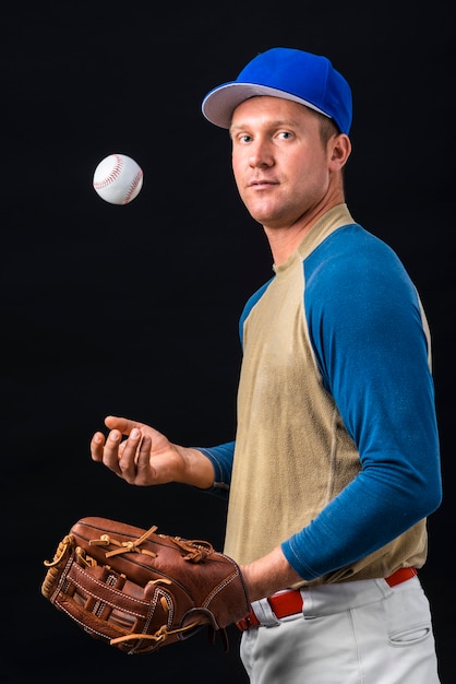 Foto vista laterale del giocatore di baseball che gioca con la palla