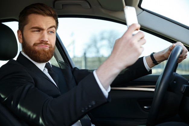 Side view of bearded business man making selfie