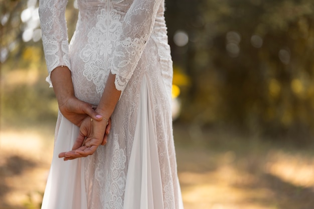 Photo side view beautiful bride posing outdoors