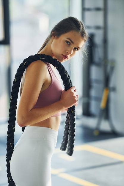 Side view beautiful young woman with slim body type is in the\
gym