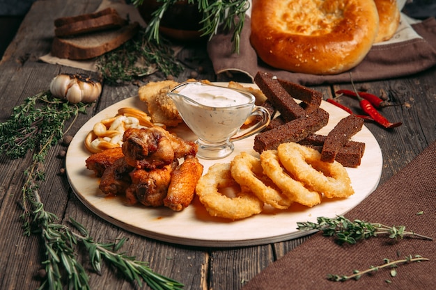 Side view on beer snacks set on the wooden board