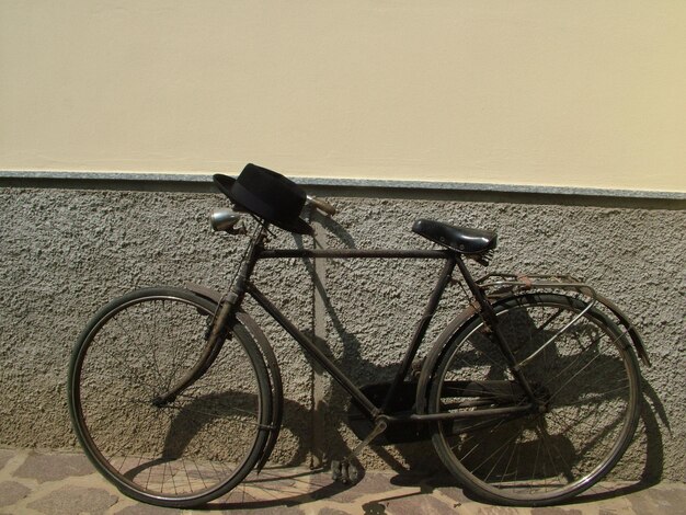 Foto vista laterale di una bicicletta parcheggiata contro il muro