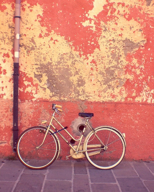 side view of bicycle parked against wall