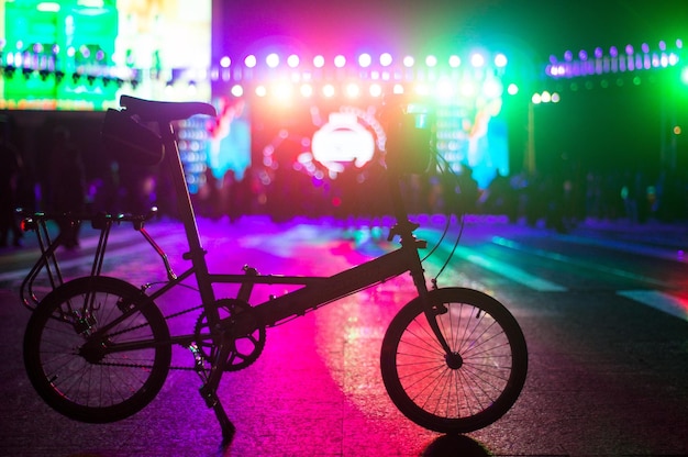 Foto vista laterale di una bicicletta sulla strada contro persone sfocate