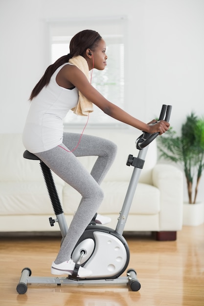 Side view of a black woman doing exercise bike