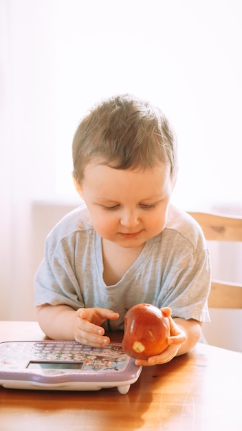 Side view of boy eating apple at home