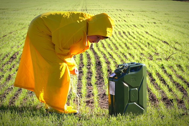 Foto vista laterale di un ragazzo sul campo con un serbatoio di benzina cambiamenti climatici