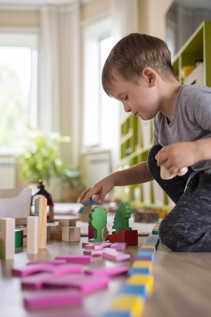 Photo side view of boy playing with toy at home