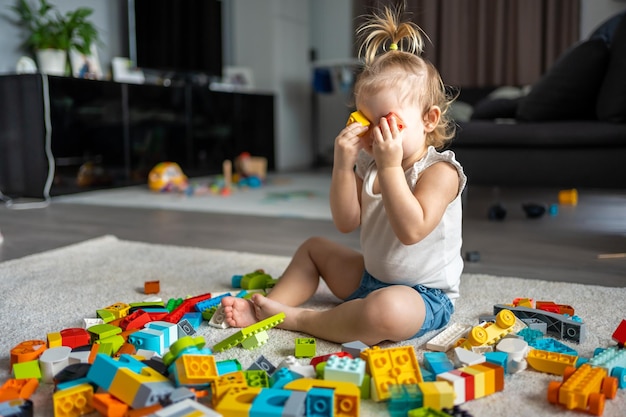 Photo side view of boy playing with toys on table