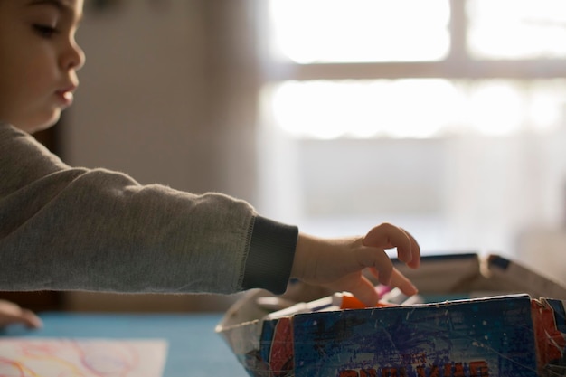 Photo side view of boy playing with toys on table