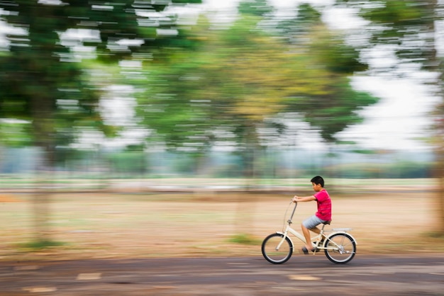 路上で自転車に乗っている男の子のサイドビュー