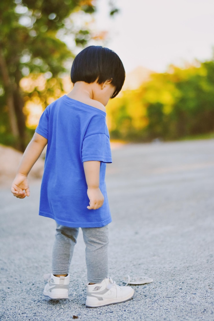 Photo 道路の上に立っている男の子のサイドビュー