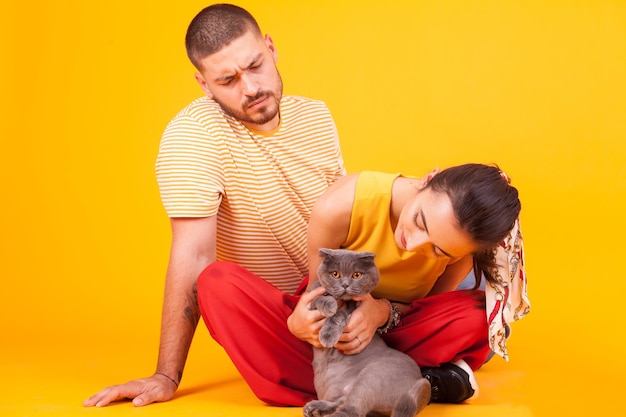 Side view of boy with dog against yellow background