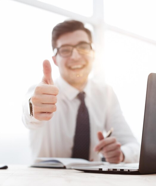 Side view of a business man working on laptop and making the ok gesture