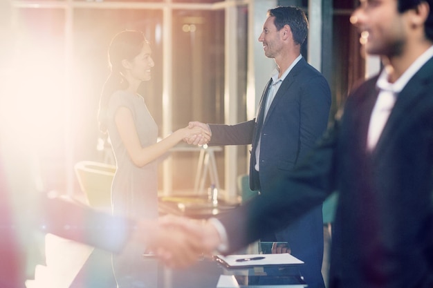 同僚と握手するビジネスマンの側面図