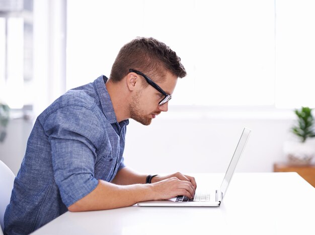 Side view of businessman using laptop at office