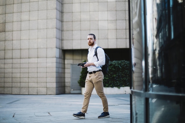 Side view of businessman walking on footpath against buildings