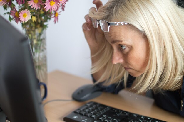 Foto vista laterale di una donna d'affari che guarda il monitor del computer in ufficio