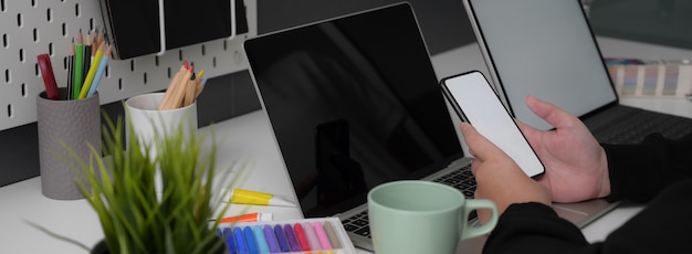 Photo side view of businesswoman working with mock-up smartphone on white table