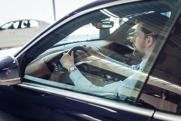 Side view of caucasian businessman in driving car