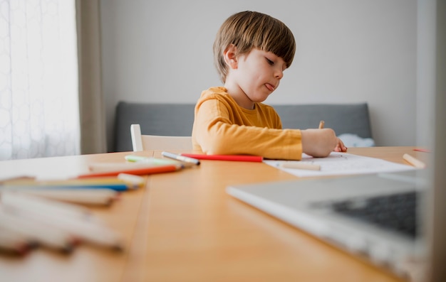 Foto vista laterale del bambino al disegno della scrivania