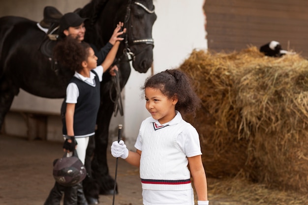 写真 馬に乗ることを学ぶ子供たちの側面図