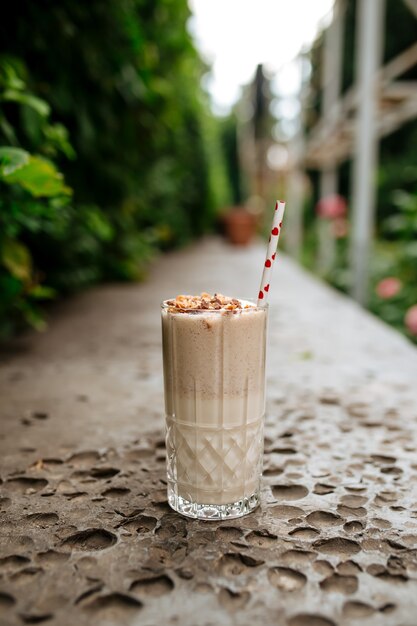 Side view on chocolate milkshake with a straw on the stone