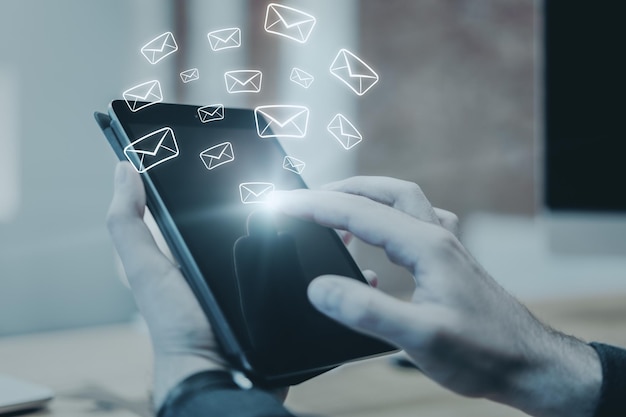 Side view and close up of hand using touchpad with glowing email network on blurry background Email marketing message and communication concept Multiexposure