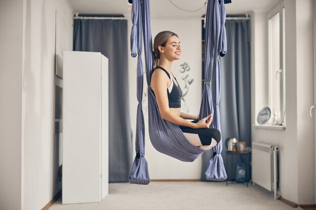 Side view of a contented female yogi with her eyes closed relaxing after the workout