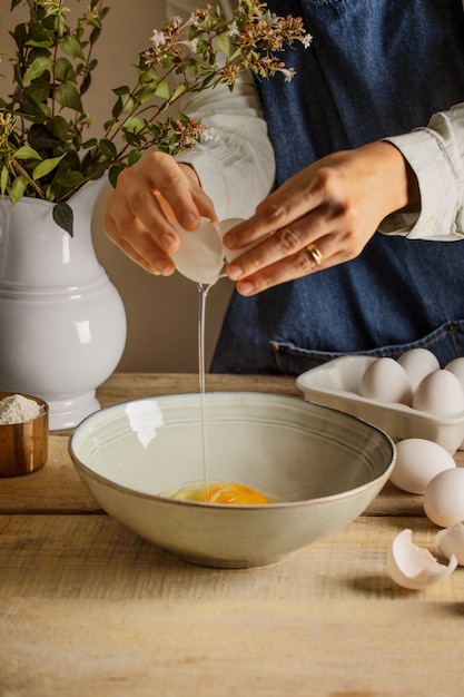 Photo side view cook cracking egg