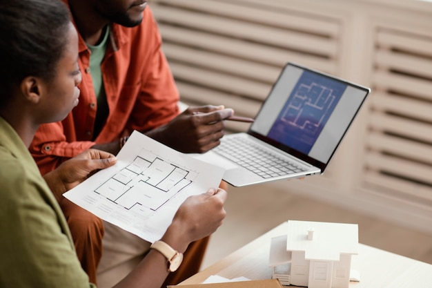 Photo side view of couple making plans for renovating home