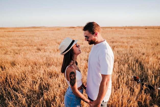 Photo side view of couple standing amidst plants in farm