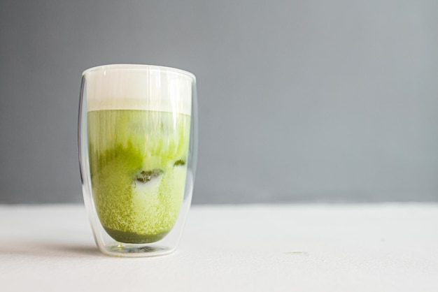 Side view on cup of green matcha tea with milk