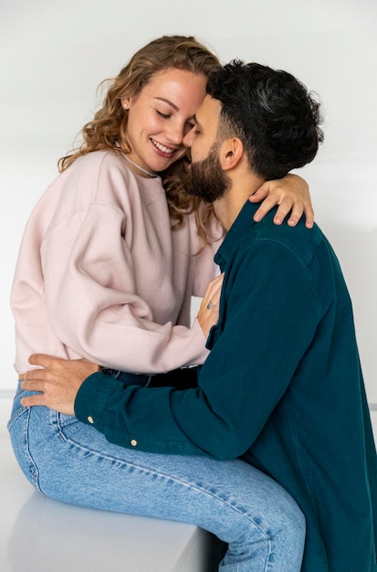 Photo side view of cute couple embraced at home