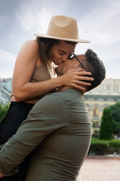 写真 サイドビューかわいいカップルが屋外でキス