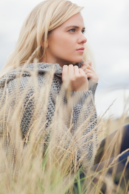 Side view of a cute thoughtful young woman lying at beach