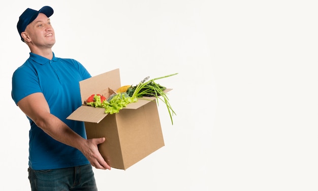 Side view of delivery man holding grocery box