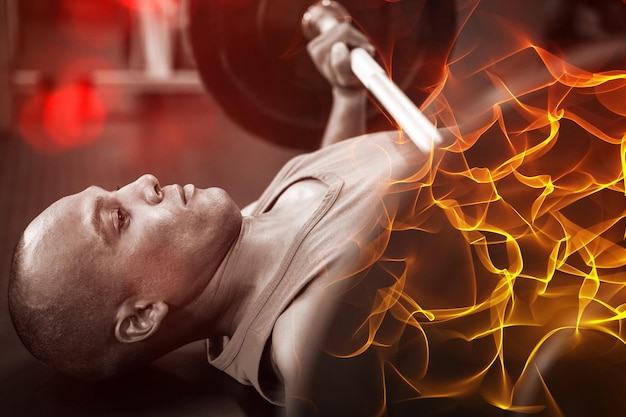 Side view of determined male athlete exercising with barbell